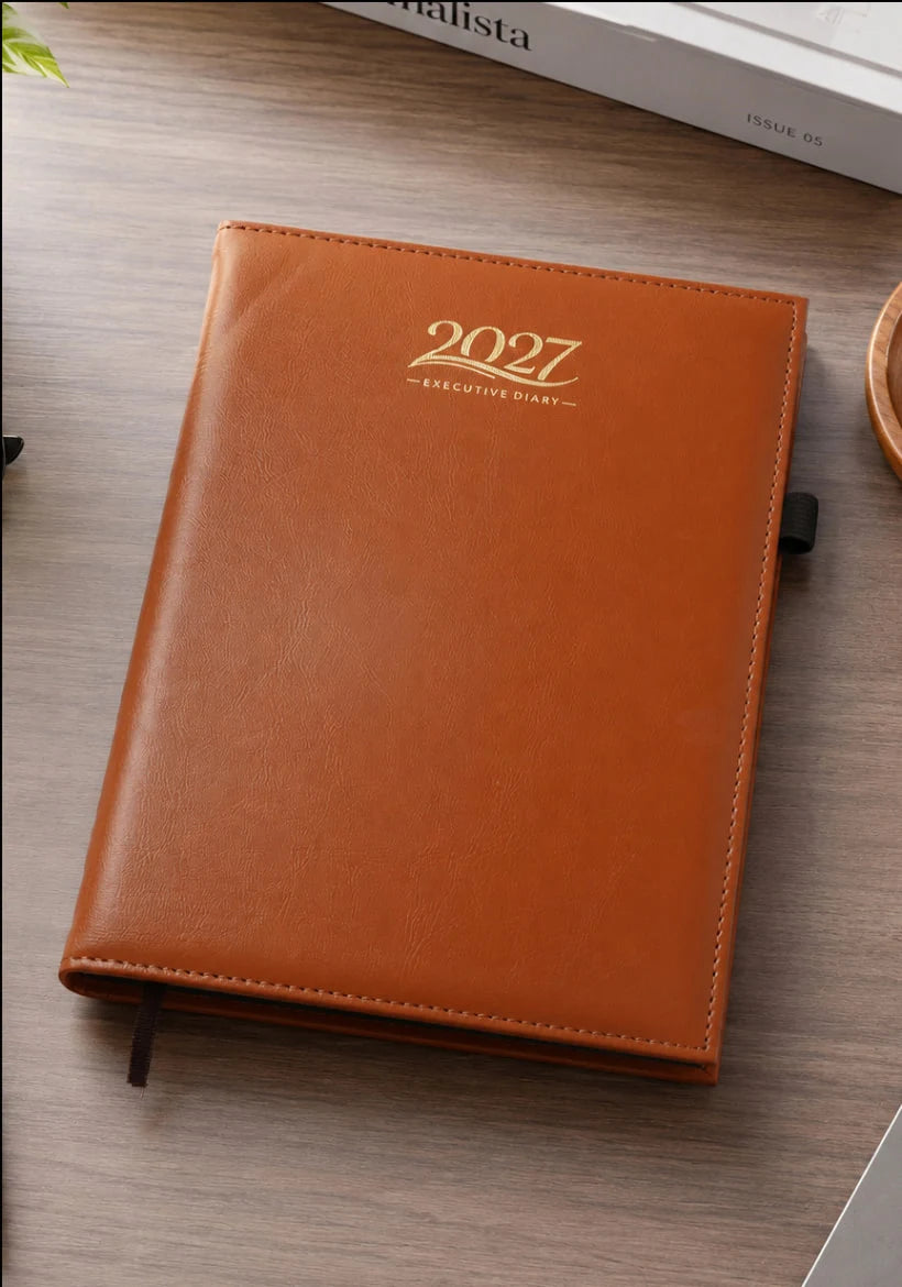 2027 tan brown foam thermal PU executive diary V-215 with stitched edges, gold-coloured lettering, side pen loop, and ribbon bookmark.